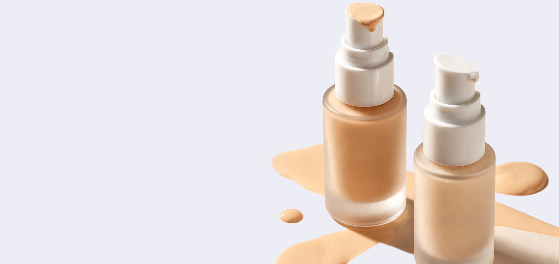 Two cosmetic bottles with foundation on a light gray background